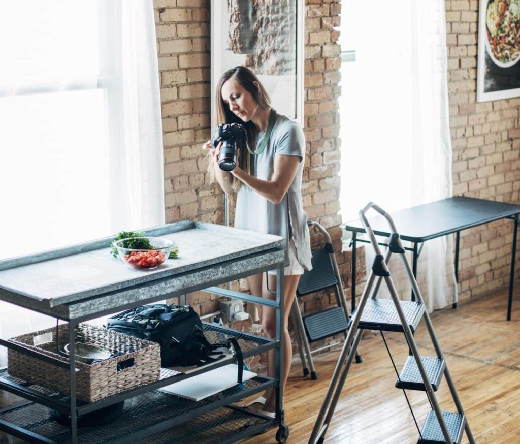 Lindsay Ostrom photographing food in the Pinch of Yum studio