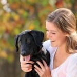 Photo of Raquel Smith holding a black dog