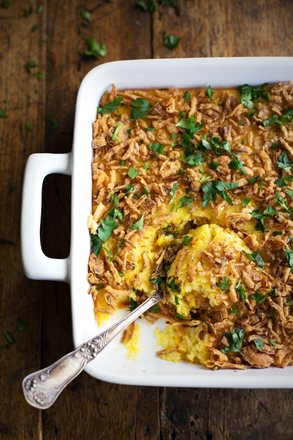 Thanksgiving casserole in a white baking dish with a spoon dug into it