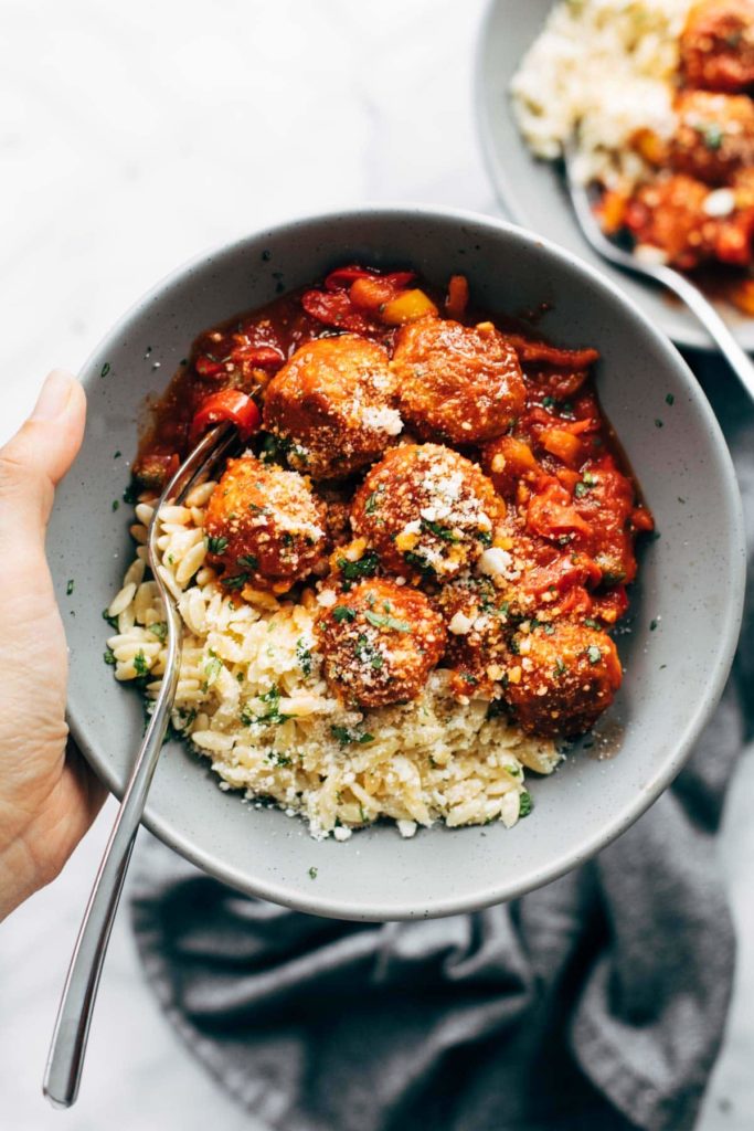 A bowl filled with pasta and meatballs photographed from overhead