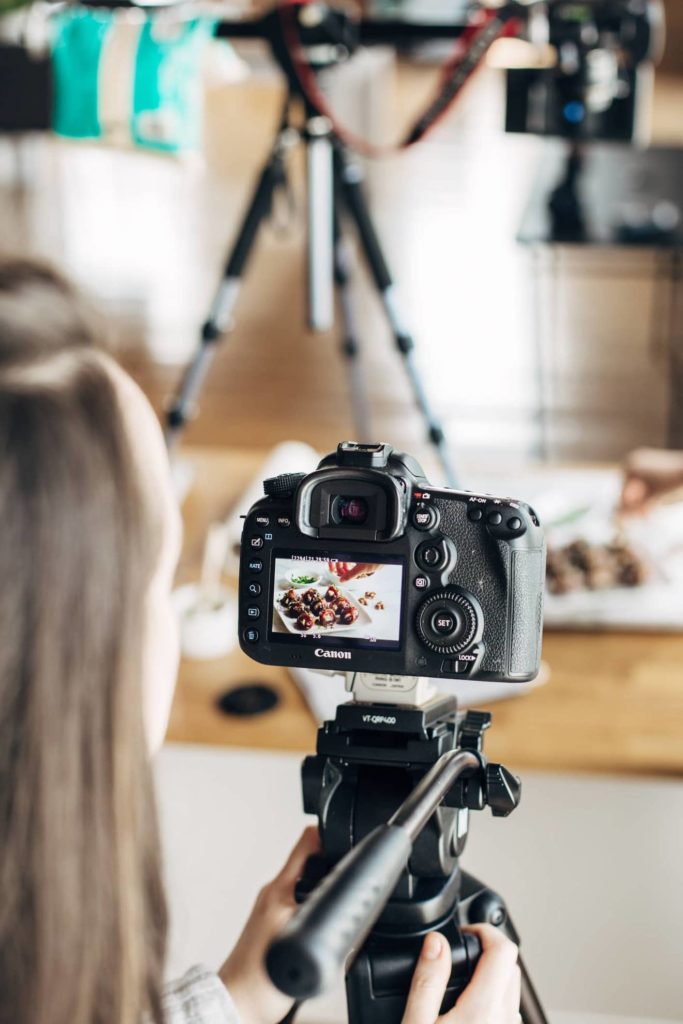 Woman using a DSLR to capture a photograph of food