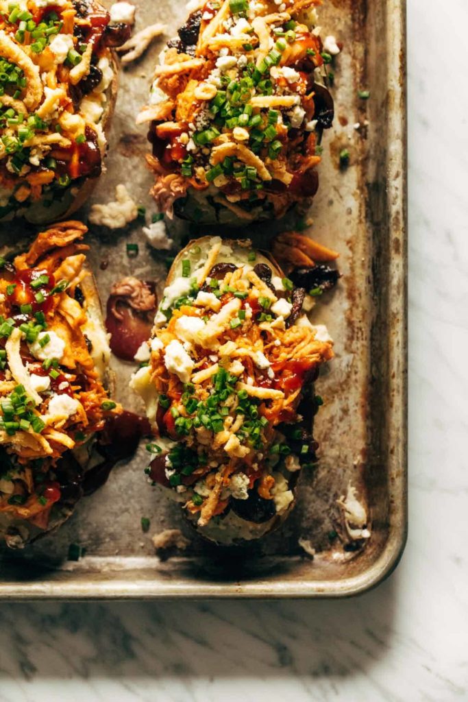 Loaded baked potatoes on a rusty cookie sheet