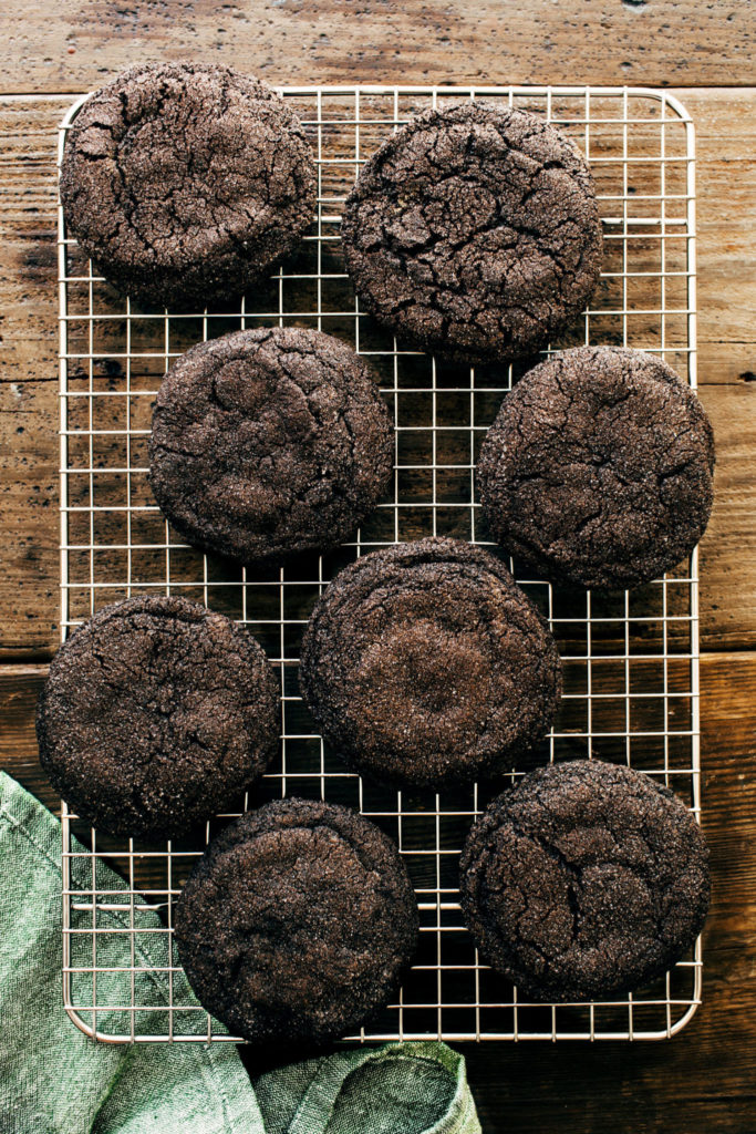 chocolate cookies on a wire cooling rack over a wood surface