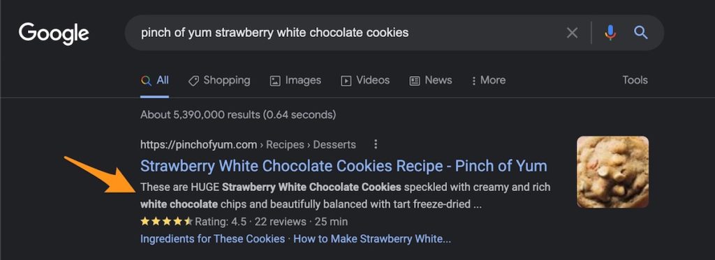 an orange arrow pointing to the meta description in a Google Search result for Pinch of Yum's Strawberry White Chocolate Cookies