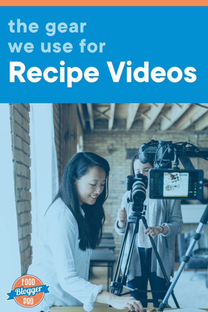 Blue image of two women setting up to take a photograph using an overhead DSLR camera and a DSLR camera mounted on a tripod. The photo reads "the gear we use for recipe videos" and has the Food Blogger Pro logo in the bottom left corner.
