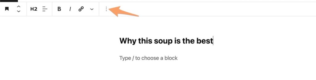 an orange arrow pointing to the block options button on WordPress