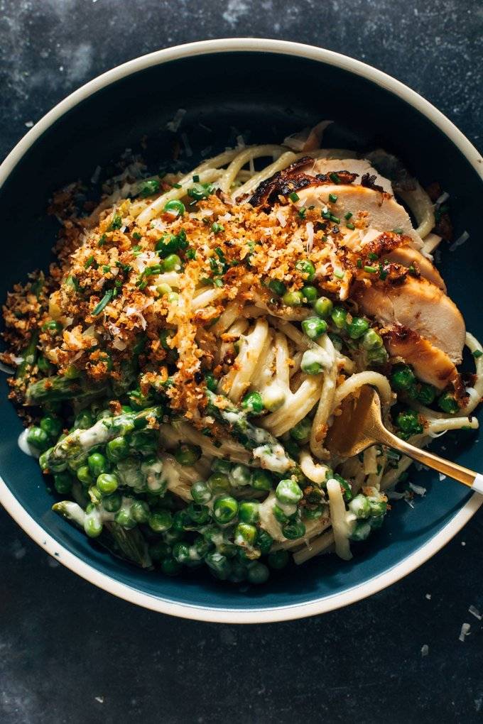 A fork twisting a bite of pasta with chicken and breadcrumbs