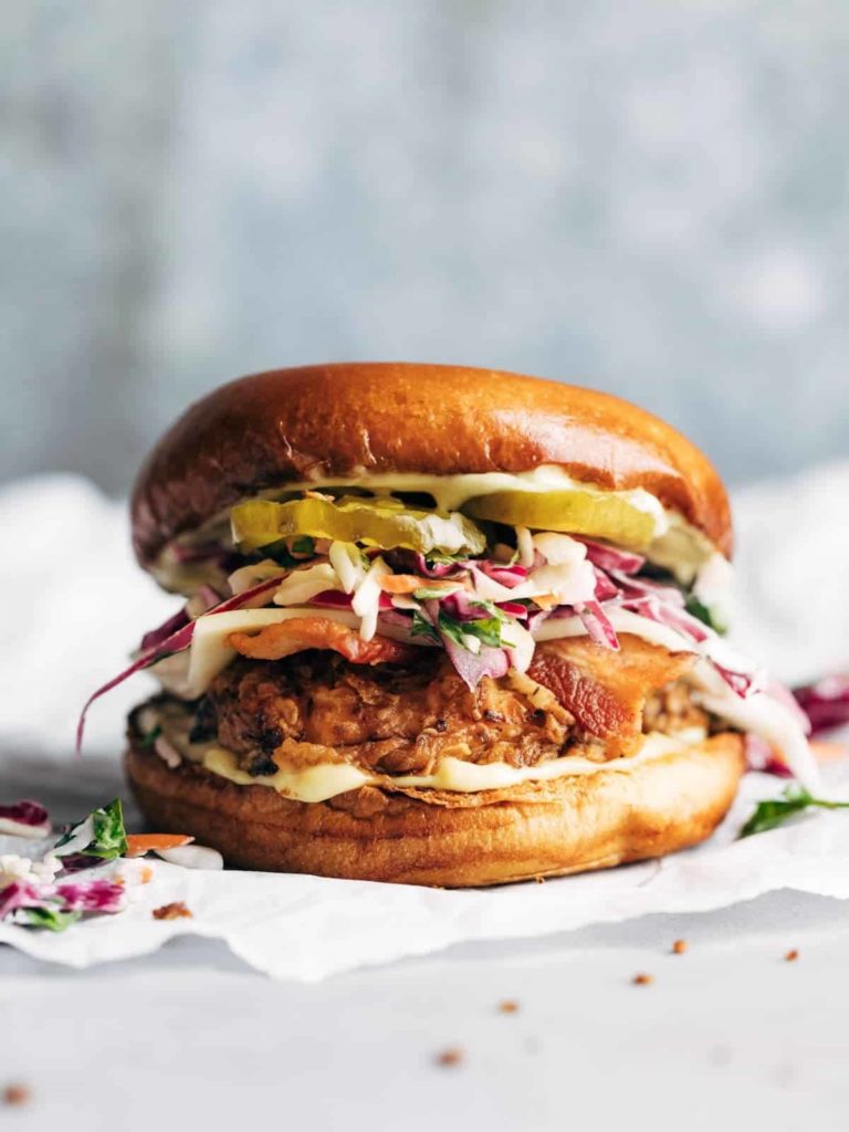 A loaded chicken sandwich in front of parchment paper