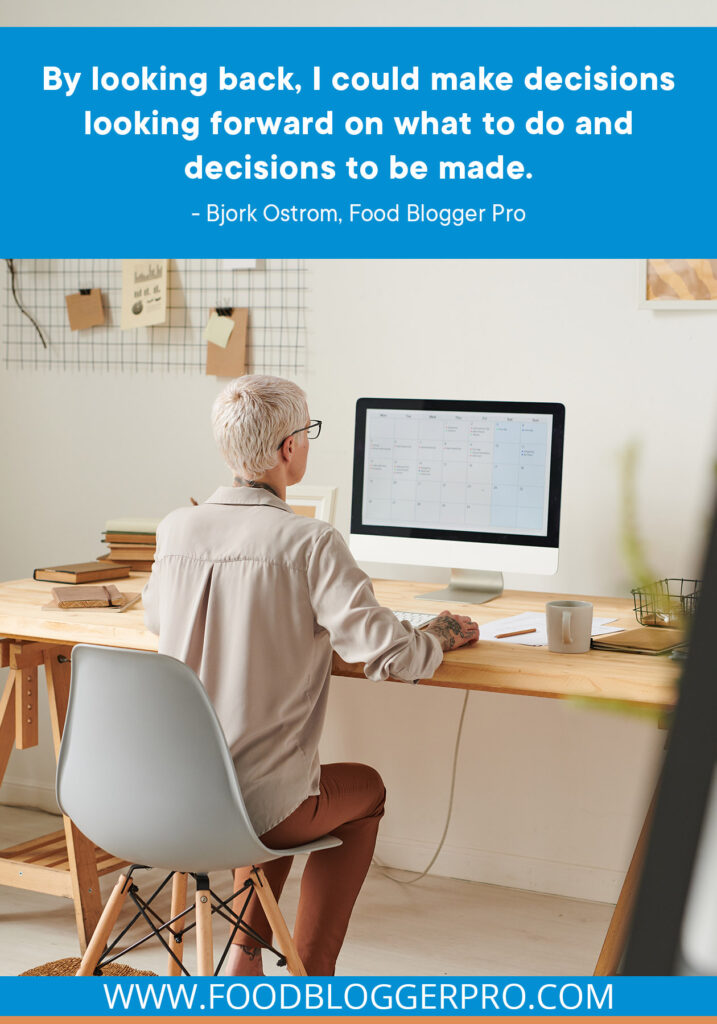 A photograph of a person sitting at a desk with a quote from episode 401 of The Food Blogger Pro Podcast: "By looking back, I could make decisions looking forward on what to do and decisions to be made."