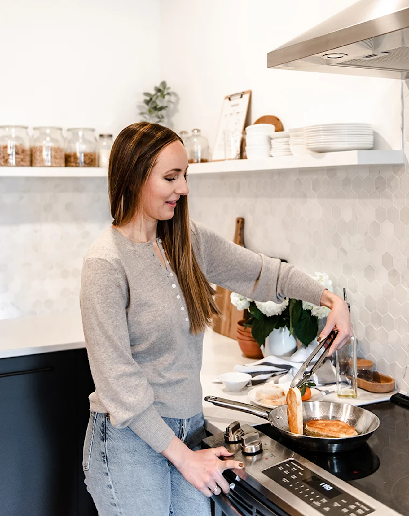 A photo of Lindsay Ostrom cooking at the stove.